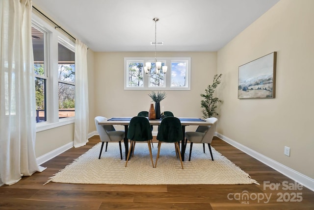 dining room featuring dark wood finished floors, a healthy amount of sunlight, and baseboards