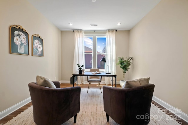 sitting room featuring visible vents, baseboards, and wood finished floors