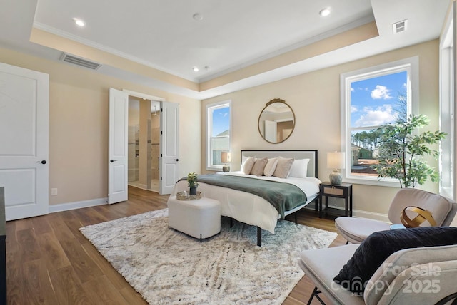 bedroom with visible vents, a raised ceiling, and dark wood finished floors