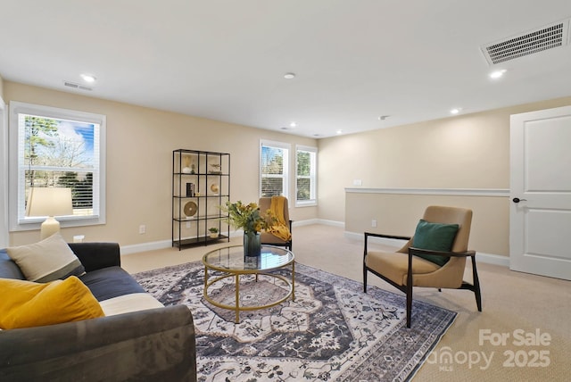 living area with recessed lighting, light colored carpet, visible vents, and baseboards