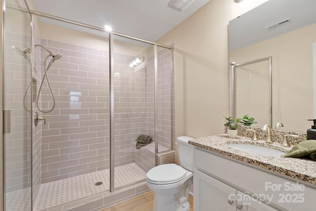 full bath featuring visible vents, toilet, a stall shower, and vanity