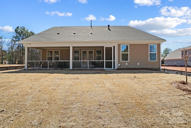 back of house featuring roof with shingles and a sunroom