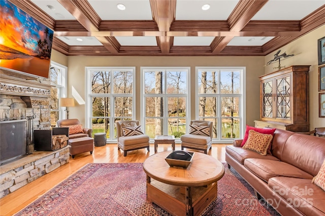 sunroom with a stone fireplace, beam ceiling, and coffered ceiling