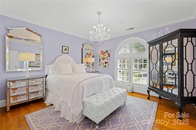 bedroom featuring visible vents, wood finished floors, and ornamental molding