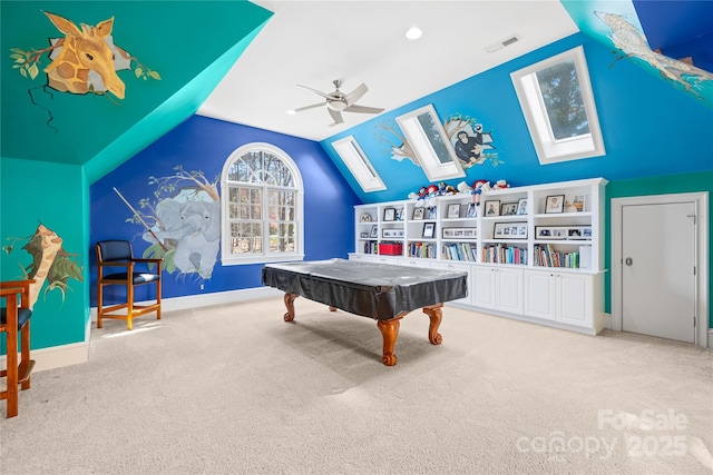 playroom featuring lofted ceiling with skylight, a ceiling fan, visible vents, and carpet floors