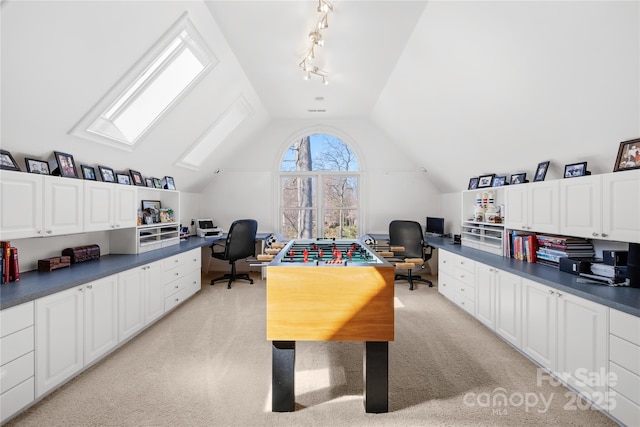 home office featuring light carpet, track lighting, and vaulted ceiling with skylight