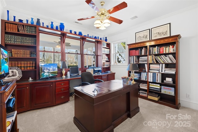 home office with crown molding, light colored carpet, visible vents, and ceiling fan