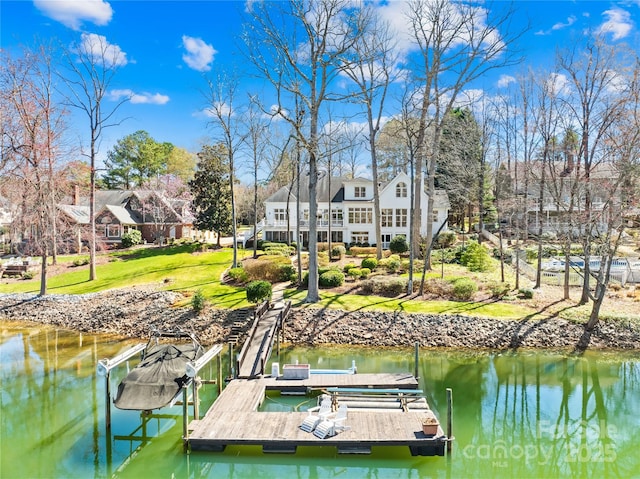 dock area featuring a lawn and a water view