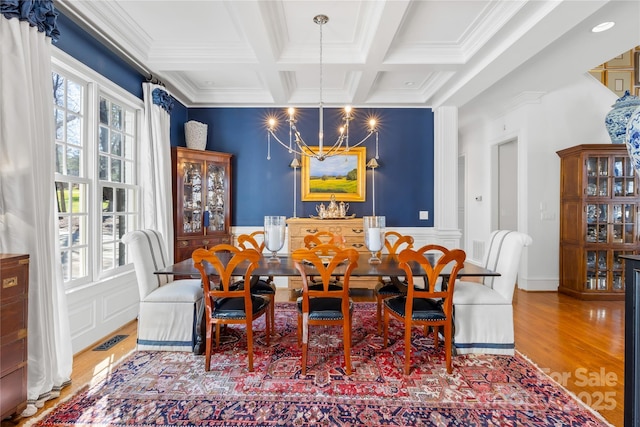 dining area with visible vents, a chandelier, beamed ceiling, wood finished floors, and coffered ceiling