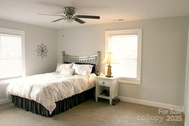 carpeted bedroom with visible vents, baseboards, and ceiling fan