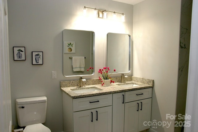 bathroom featuring a sink, toilet, and double vanity