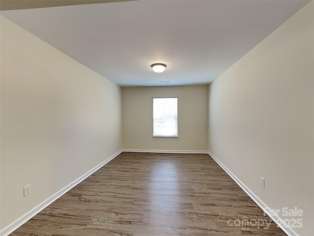 empty room with wood finished floors and baseboards