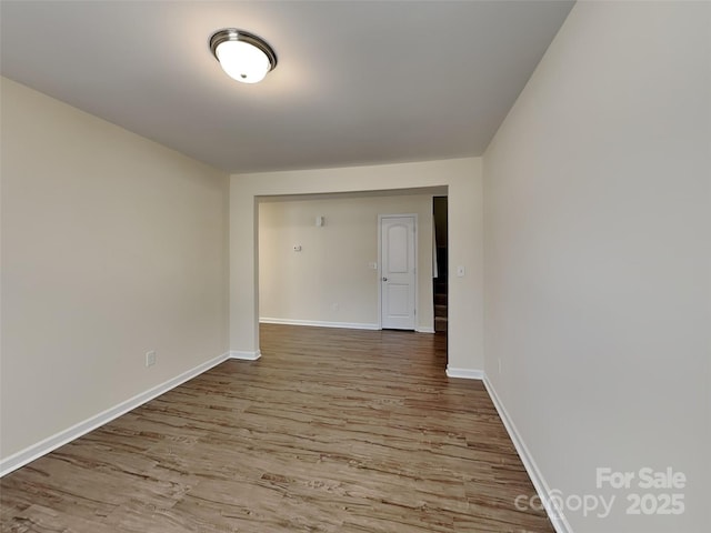 unfurnished room featuring baseboards and wood finished floors