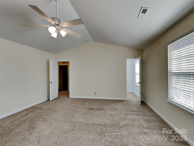 unfurnished room featuring visible vents, light colored carpet, baseboards, and vaulted ceiling