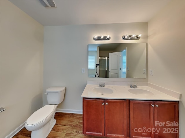 bathroom featuring a shower stall, toilet, visible vents, and a sink