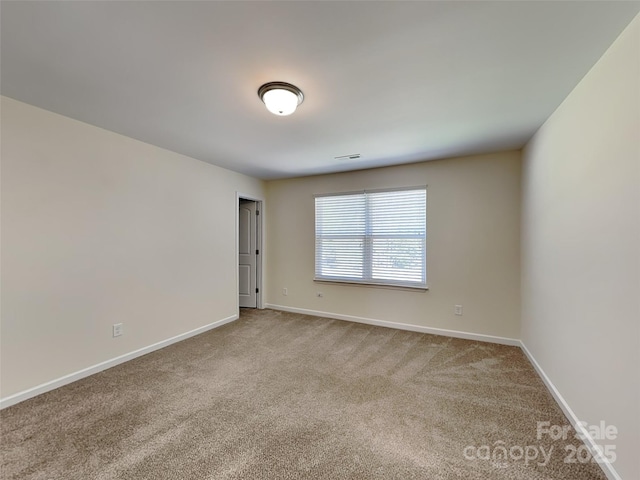 carpeted empty room with visible vents and baseboards