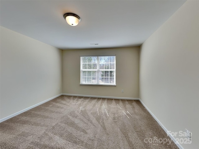 carpeted empty room with baseboards