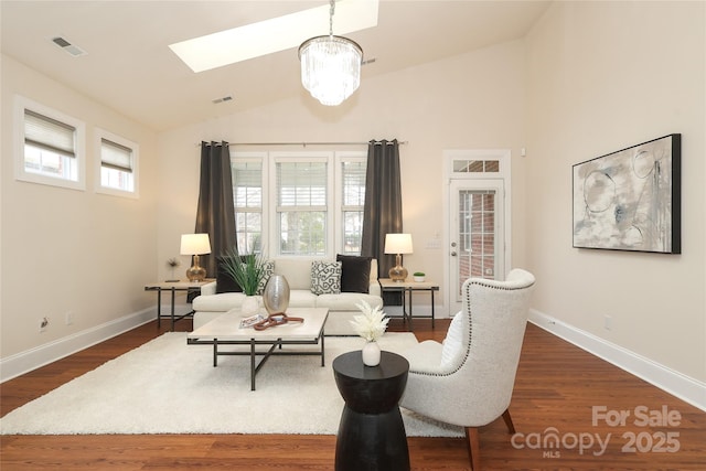 living room featuring visible vents, lofted ceiling with skylight, baseboards, and dark wood-style floors