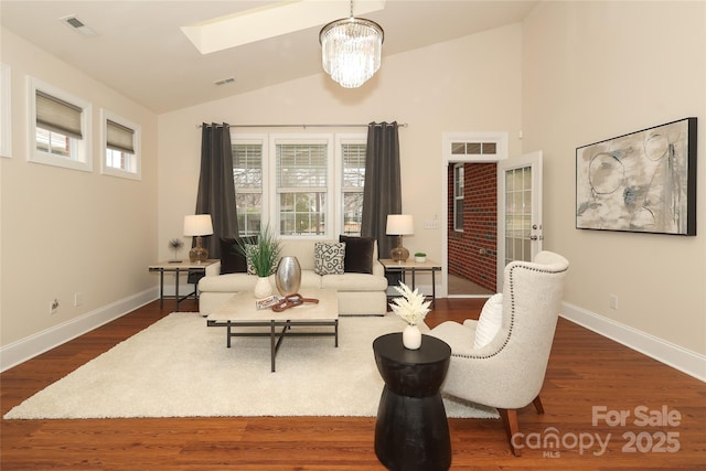 living room featuring visible vents, lofted ceiling with skylight, baseboards, and dark wood-style floors