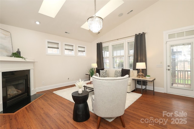 living room with wood finished floors, a skylight, a healthy amount of sunlight, and visible vents