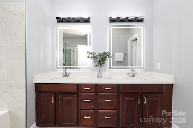 bathroom featuring double vanity, a shower, and a sink