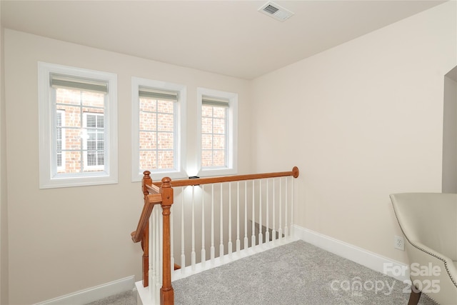 stairway with visible vents, baseboards, and carpet floors