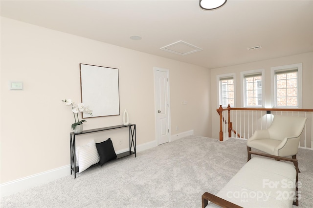 sitting room featuring baseboards, carpet flooring, attic access, and visible vents