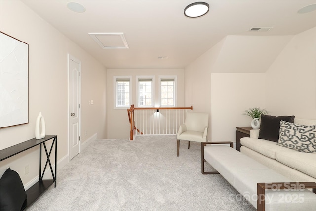 living area with attic access, an upstairs landing, visible vents, and carpet floors