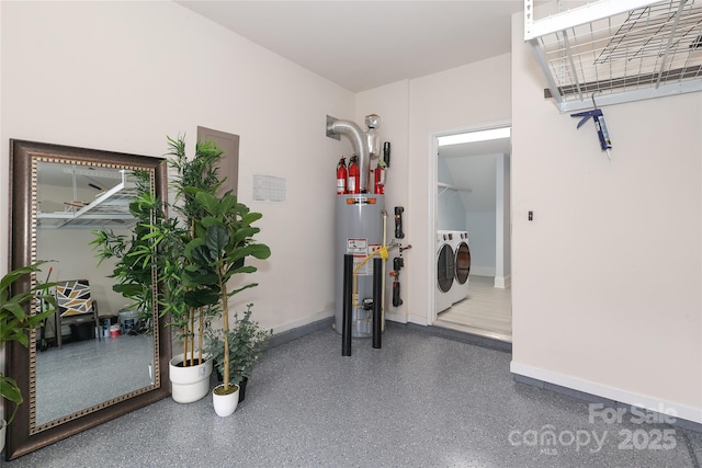 garage featuring baseboards, water heater, and washing machine and clothes dryer