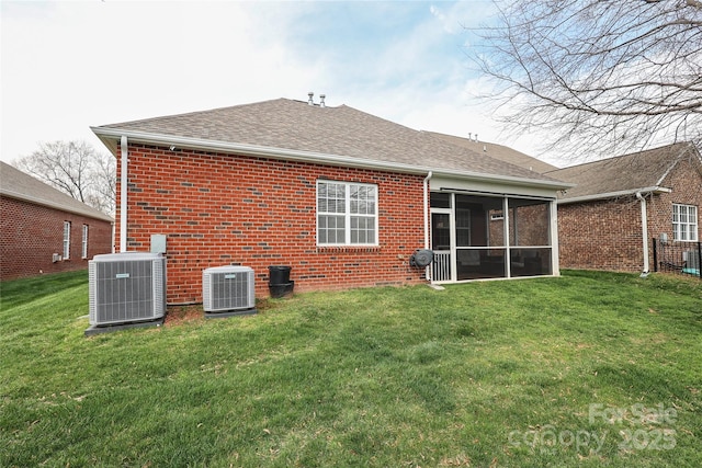 back of house featuring cooling unit, brick siding, a sunroom, and a yard