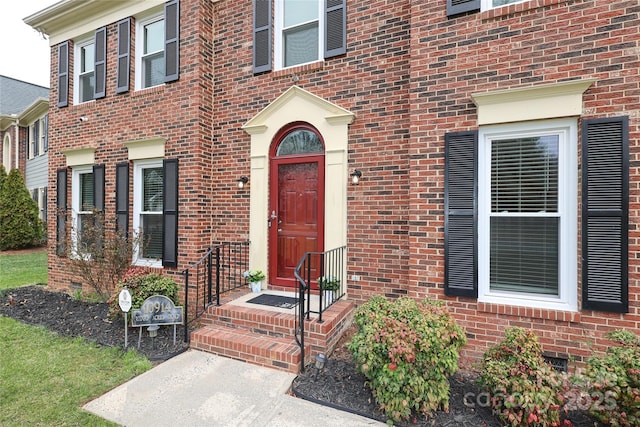 entrance to property featuring brick siding and crawl space