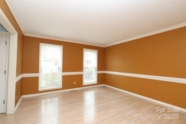 unfurnished room featuring visible vents, baseboards, light wood-style floors, and ornamental molding