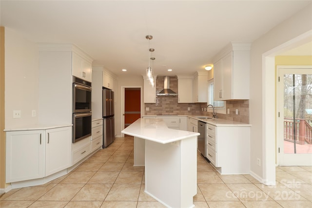 kitchen with a sink, tasteful backsplash, appliances with stainless steel finishes, wall chimney range hood, and light tile patterned floors