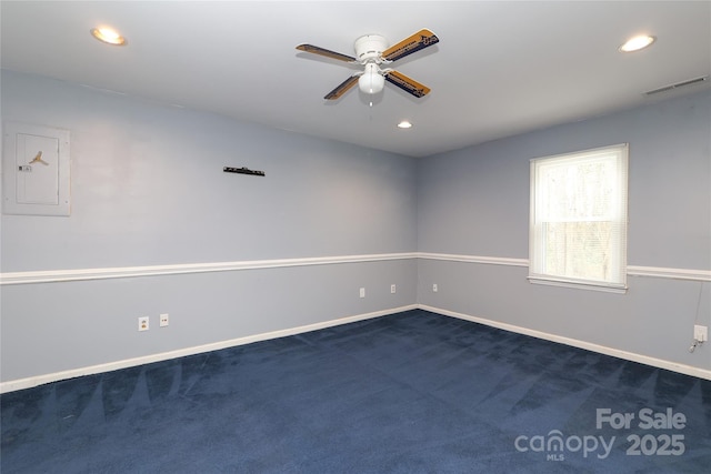 unfurnished room with visible vents, baseboards, dark carpet, electric panel, and recessed lighting