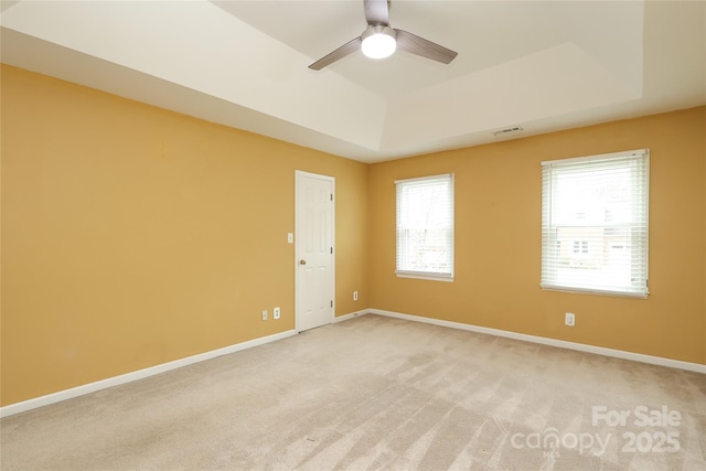 unfurnished room with visible vents, baseboards, and a tray ceiling