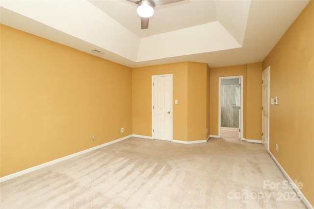 empty room with visible vents, light colored carpet, baseboards, and ceiling fan