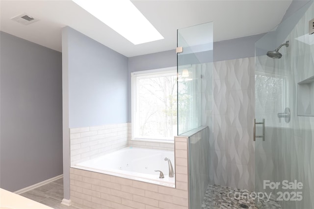 bathroom featuring visible vents, a shower stall, a skylight, and a whirlpool tub