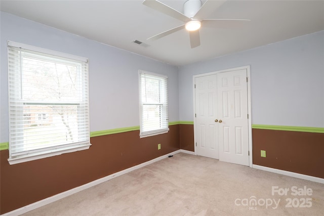 unfurnished bedroom featuring visible vents, baseboards, a closet, and carpet flooring