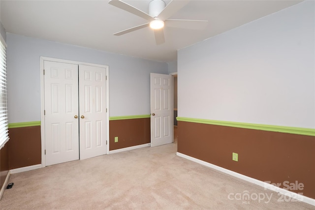 unfurnished bedroom with a ceiling fan, carpet, a closet, and baseboards