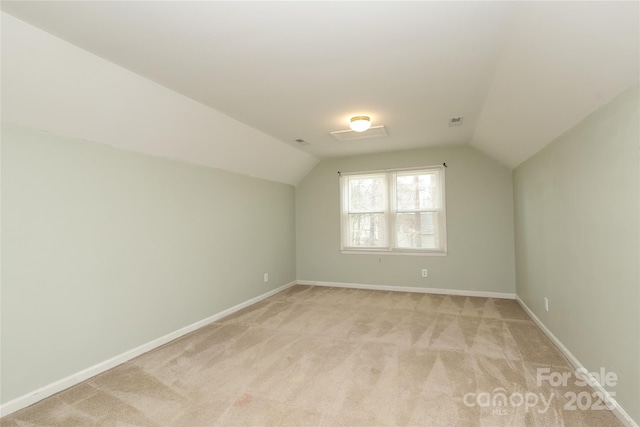 bonus room with vaulted ceiling, visible vents, baseboards, and light carpet