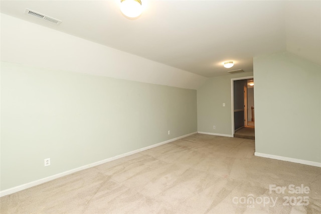 bonus room featuring vaulted ceiling, baseboards, visible vents, and light carpet