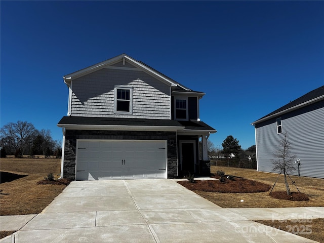 view of front of home featuring stone siding, an attached garage, and concrete driveway