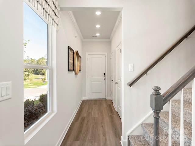 corridor with recessed lighting, stairs, crown molding, and baseboards