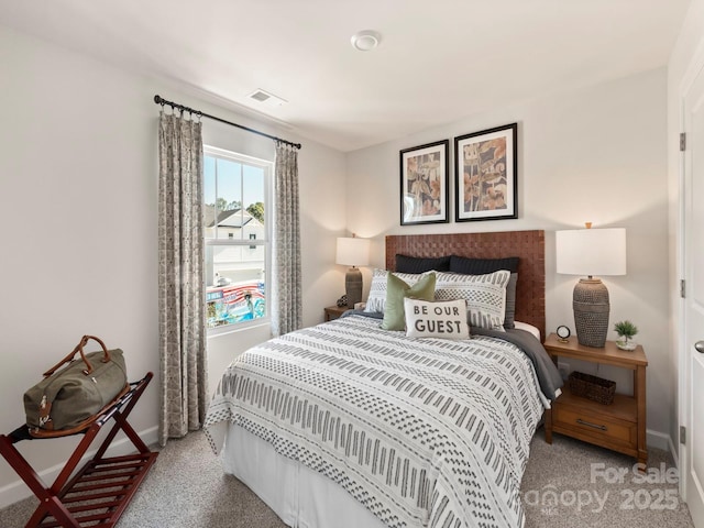 bedroom with baseboards, visible vents, and light carpet