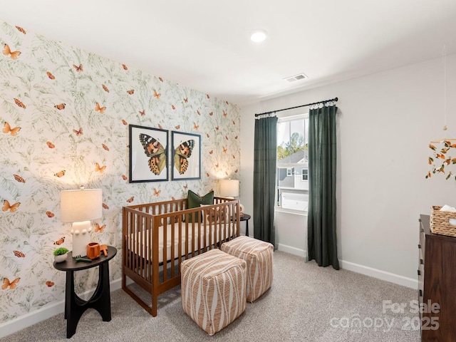 carpeted bedroom featuring visible vents, wallpapered walls, and baseboards