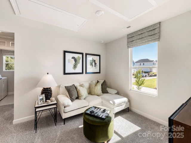 living room with visible vents, washing machine and dryer, carpet flooring, baseboards, and attic access