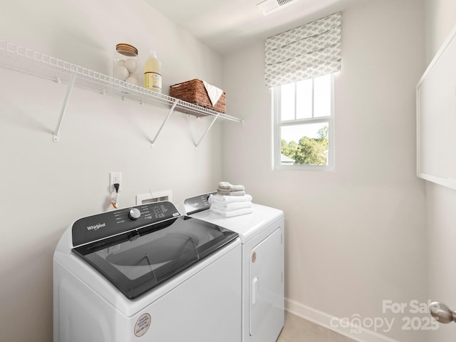 washroom featuring light tile patterned floors, visible vents, baseboards, laundry area, and separate washer and dryer