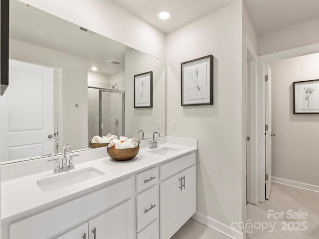 bathroom with double vanity, a stall shower, visible vents, and a sink