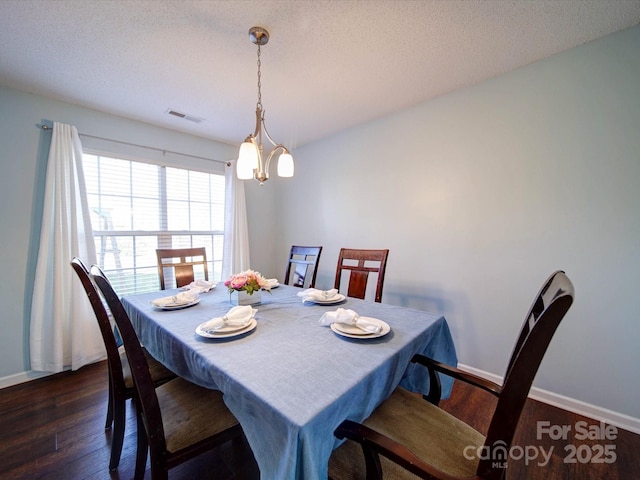 dining space with visible vents, baseboards, a textured ceiling, and dark wood-style floors