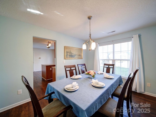 dining room with visible vents, dark wood-type flooring, a notable chandelier, a textured ceiling, and baseboards